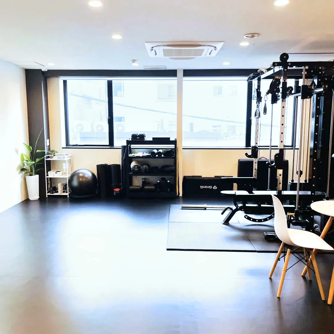 大きな窓から自然光が入る、福岡・天神エリアのHABIT. bloomのスタジオ。観葉植物とバランスボールのある明るい室内